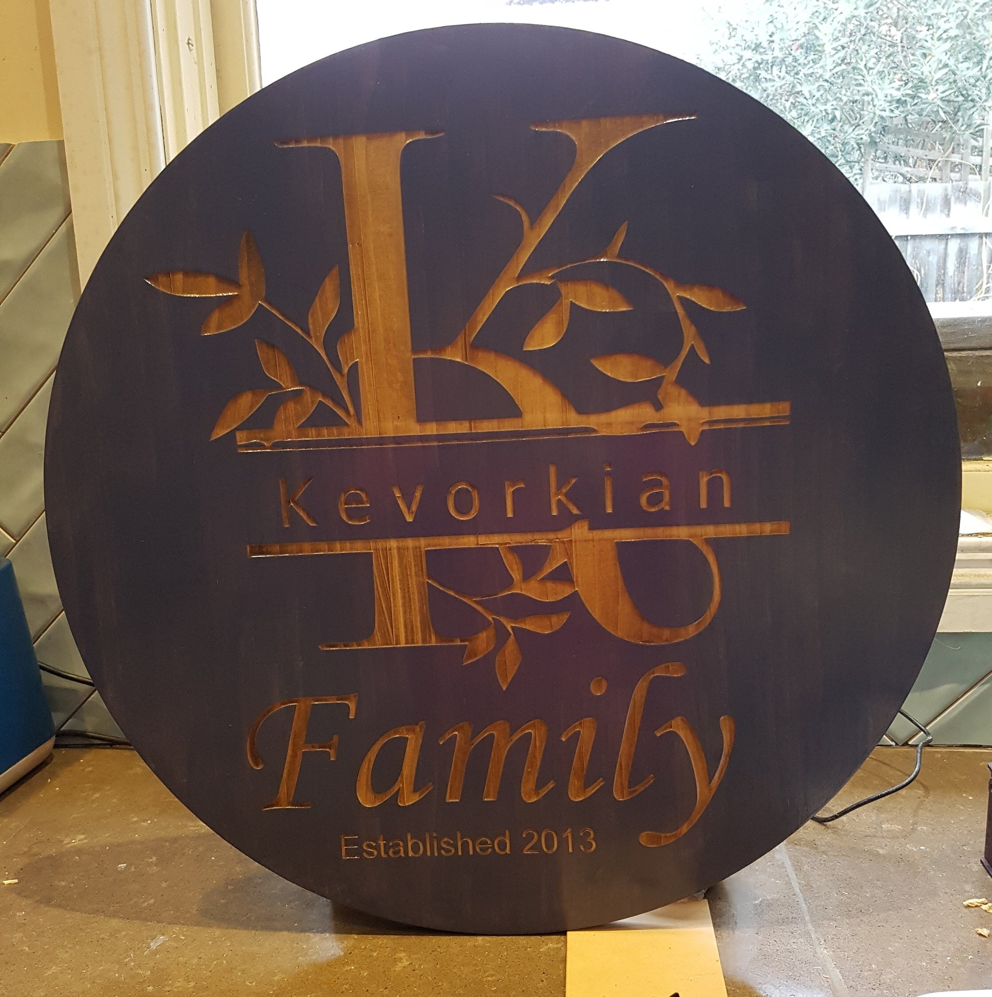 Personalized Laser Engraved Round Family Signs – Crafted Elegance for Timeless Memories. Leafy split monogram with Famiily name and year couple were married. Stained in Deep Purple.