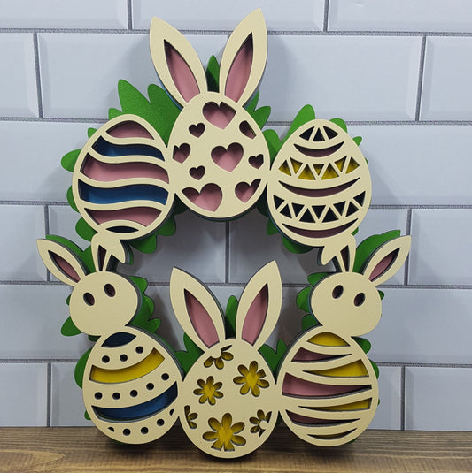 Introducing our 6-layered MDF laser-cut Easter wreath, measuring 17cm wide x 20cm high. Adorned with charming eggs, some featuring bunny heads and ears, this wreath adds whimsical charm to your Easter decor. Crafted with precision and showcasing vibrant layers, it's a perfect centerpiece or wall accent for the season. From Turtle and Wolf Makers and Crafters.