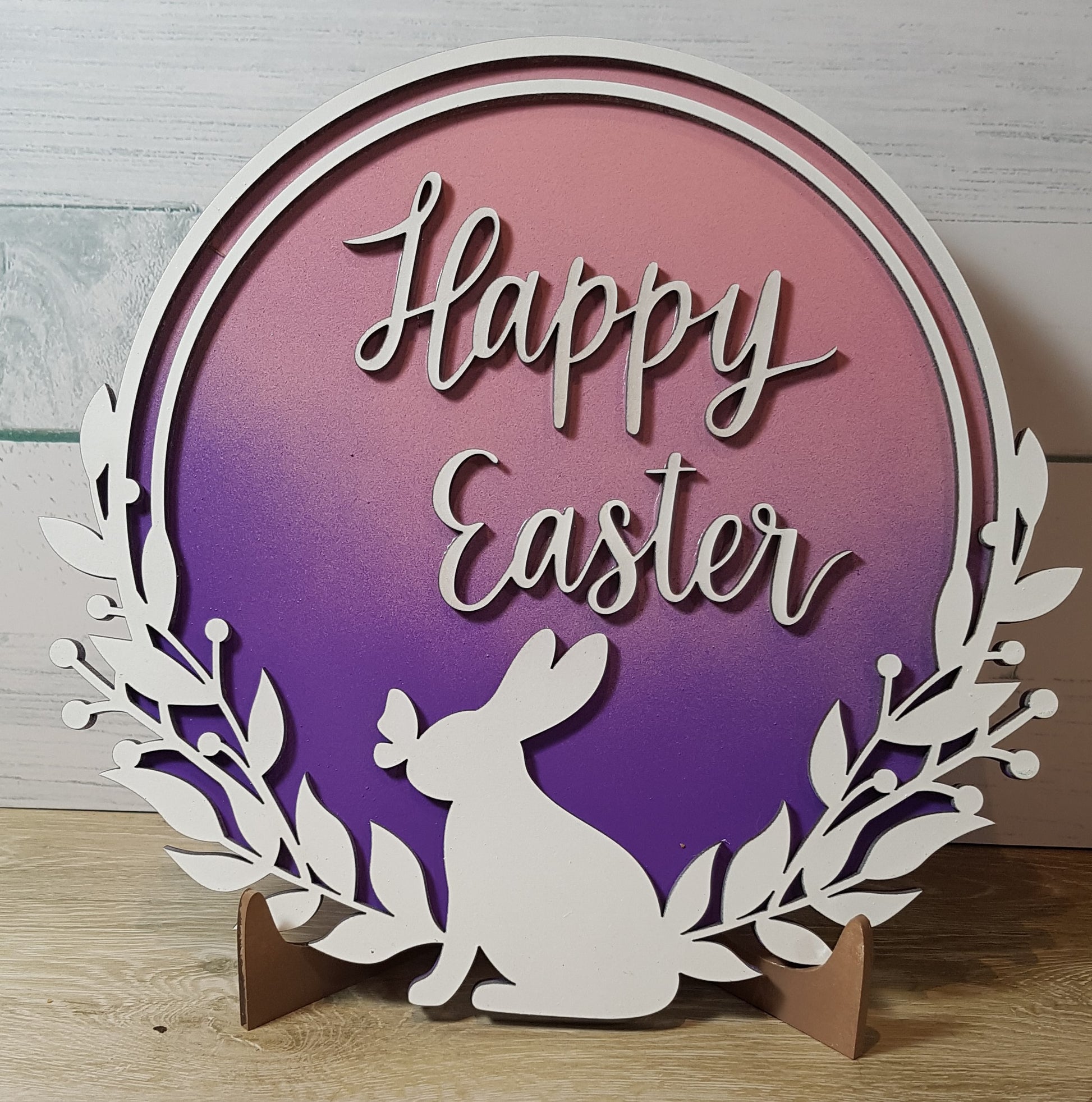 Elevate your Easter decor with our enchanting round Happy Easter sign. Featuring a charming bunny silhouette with a butterfly on its nose and the words "Happy Easter," this 21cm x 21cm round sign is available in five stunning 2-toned ombre effects. Perfect for spreading joy and celebrating the season