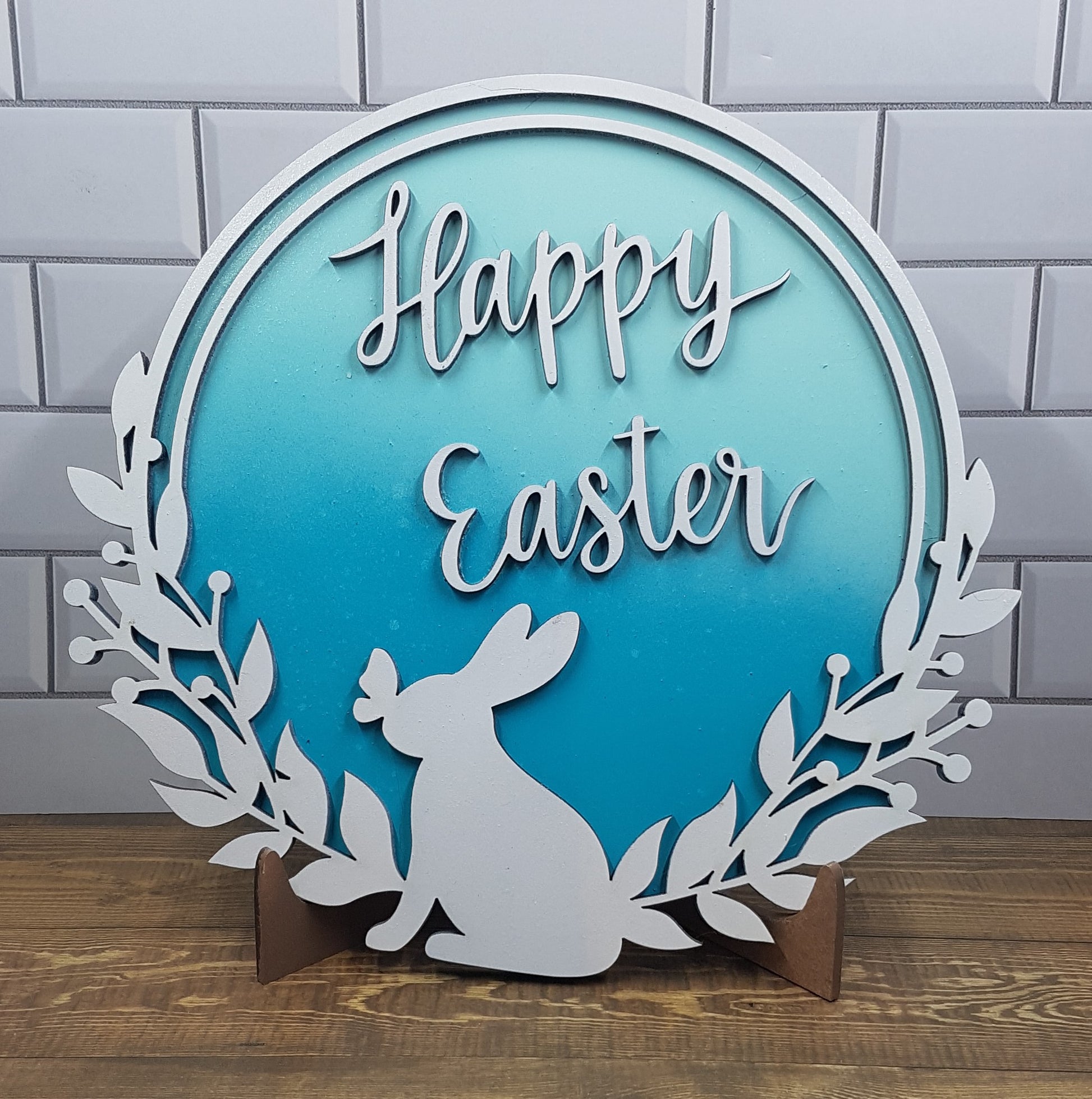 Elevate your Easter decor with our enchanting round Happy Easter sign. Featuring a charming bunny silhouette with a butterfly on its nose and the words "Happy Easter," this 21cm x 21cm round sign is available in five stunning 2-toned ombre effects. Perfect for spreading joy and celebrating the season