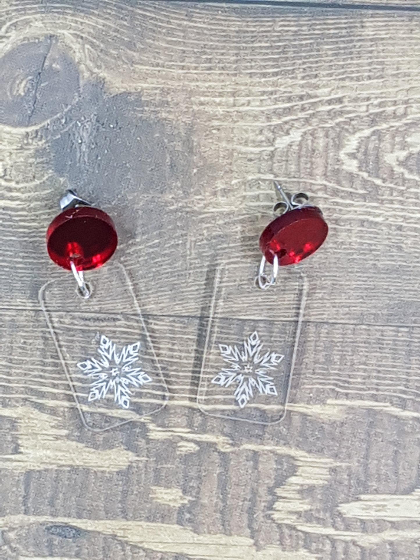 Etched snowflake into clear acrylic earring with circular red mirror topper.