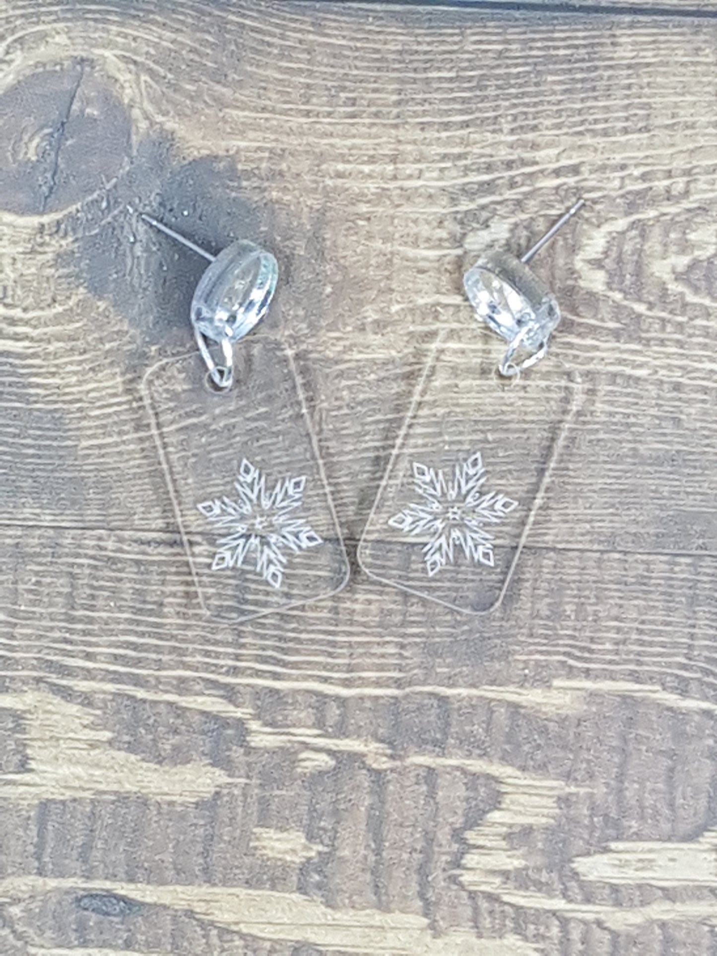 Etched snowflake into clear acrylic earring with circular silver mirror topper.