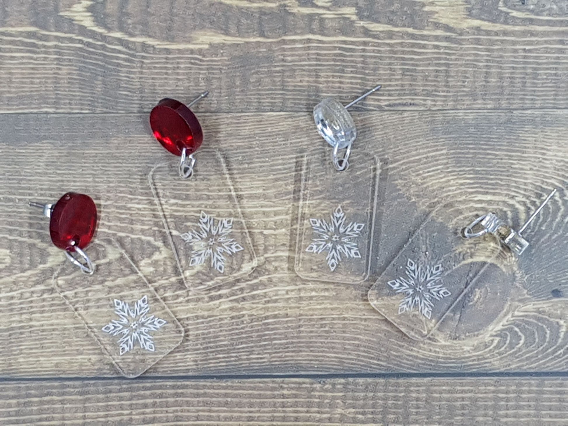 Etched snowflake into clear acrylic earring with circular silver and red mirror topper.